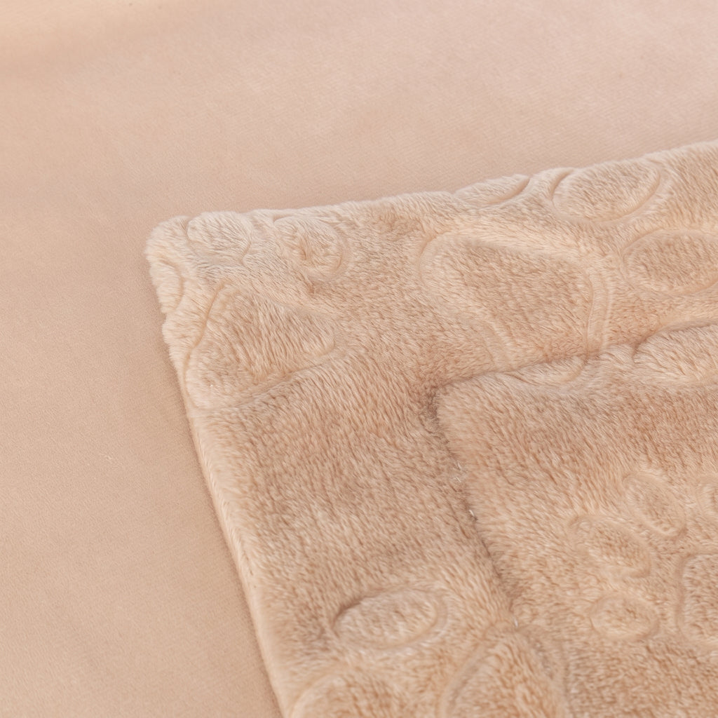 Détail de la couverture Barry pour chien, illustrant la double épaisseur, l'aspect velours lisse d'un côté et la peluche douce avec motifs de pattes en relief de l'autre.